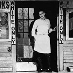 Shopkeep outside store with "Whites Only" sign, 1950. (Getty Images)